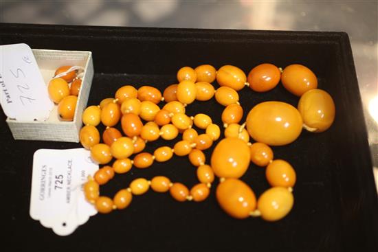 A single strand graduated oval amber bead necklace and pair of double bead earrings, 39in.